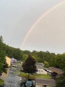 een regenboog in de lucht boven een parkeerplaats met een park bij Fran Cove Motel in Lake George