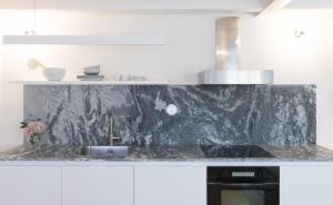 een keuken met een granieten aanrecht en een wastafel bij Souto Apartments in Porto +109 foto's