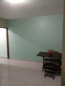 uma sala de jantar com uma mesa e uma parede azul em Apartamento NA PRAIA, 2 suites com cozinha em Ilhéus
