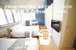 a hotel room with two beds and a television at Dot Glamping 富士山 in Fujikawaguchiko