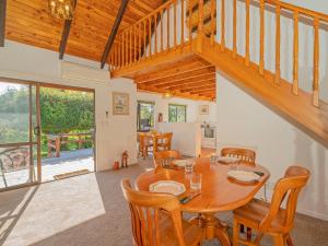 - une salle à manger avec une table et des chaises en bois dans l'établissement Sea Breeze Sanctuary - Pauanui Holiday Home, à Pauanui