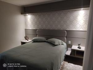 a bedroom with a large bed and two night stands at Lindo apartamento no centro de Canela in Canela
