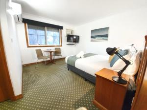 a hotel room with a bed and a desk at Bell Motel in Melbourne