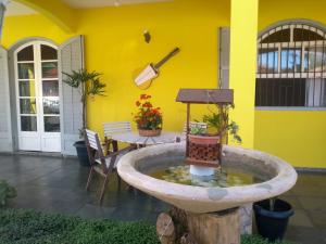 a yellow house with a fountain in the yard at Pousada Clave de Sol in Conservatória