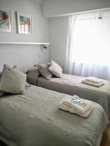 een slaapkamer met 2 bedden en handdoeken bij Retiro Lovely and Modern Apartment in Buenos Aires