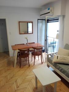 een woonkamer met een houten tafel en stoelen bij Retiro Lovely and Modern Apartment in Buenos Aires