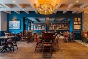 a dining room with tables and chairs and a chandelier at The Bold Hotel; BW Signature Collection in Southport