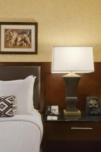 ein Schlafzimmer mit einem Bett, einer Lampe und einem Telefon in der Unterkunft Crowne Plaza Denver International Airport, an IHG Hotel in Denver