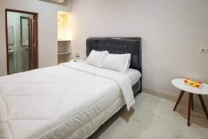 a bedroom with a large white bed and a table at Rudi Rooms near Stasiun Cikarang Mitra RedDoorz in Jakarta