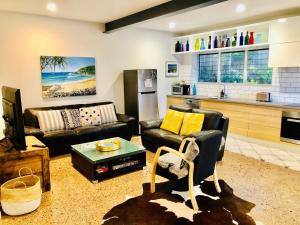 una sala de estar con un sofá y una mesa en Malibu Apartment - Peregian Beach, en Peregian Beach
