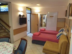 Cette petite chambre comprend deux lits et une table. dans l'établissement Shefer Guesthouse, à Eilat