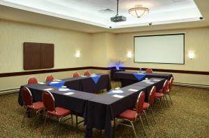 a conference room with tables and chairs and a screen at Holiday Inn & Suites Winnipeg Downtown, an IHG Hotel in Winnipeg