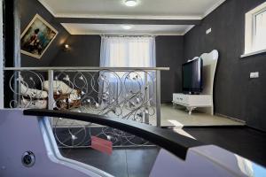 Habitación con balcón, TV y sala de estar. en Hotel Lux Aquapark, en Poltava