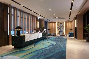 two people sitting at a reception desk in a lobby at COZZI Blu in Zhongli