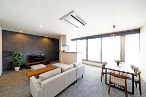 een woonkamer met een bank en een tafel bij STAY & GO Shinsaibashi-Kita in Osaka