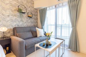 Bijou Suites Lieto APM في أوساكا: غرفة معيشة مع أريكة وطاولة