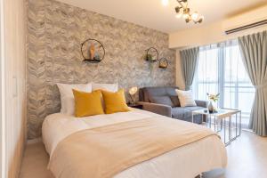 大阪Bijou Suites Lieto APM的带一张大床和一张沙发的卧室