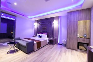 Purple Rainbow Motel في تايبيه: غرفة نوم أرجوانية مع سرير ومدفأة