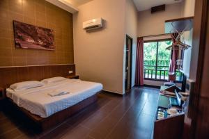 um quarto de hotel com uma cama e uma janela em Sentosa Villa em Taiping
