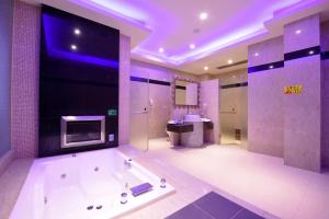 un ampio bagno con una grande vasca e una TV di Purple Rainbow Motel a Taipei Altre 37 foto