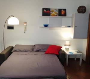 Schlafzimmer mit einem Bett mit einem roten Kissen und einem Tisch in der Unterkunft Casa Diego in Cagliari