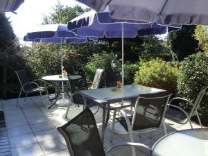 two tables and chairs with umbrellas on a patio at Hotel Nordic in Norderstedt