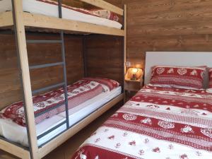 two bunk beds in a room with wooden walls at Azienda Agricola Agriturismo I Sei Petali in Capo di Ponte