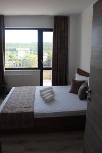 a bedroom with a large bed with towels on it at Weißer Schwan Белият лебед in Shkorpilovtsi +49 photos