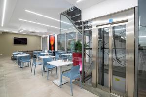 een restaurant met tafels en blauwe stoelen in een kamer bij Sundeck Hotel in San Vito lo Capo