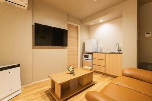 a living room with a couch and a table at GRAND BASE Hakatamon in Fukuoka