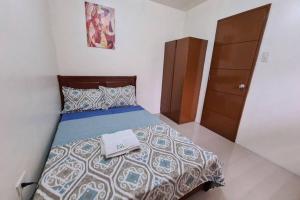 a bedroom with a bed with a towel on it at Cozy Space Near SM with Netflix and Fiber WiFi in Batangas City