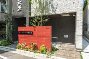 uma parede de tijolos vermelhos em frente a um edifício em GRAND BASE Hakatamon em Fukuoka