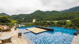 a large swimming pool with mountains in the background at Kinugawa Hotel Mikazuki in Nikko