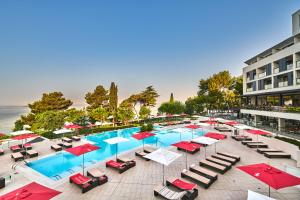an overhead view of a pool with chairs and umbrellas at Hotel Parentium Plava Laguna in Poreč
