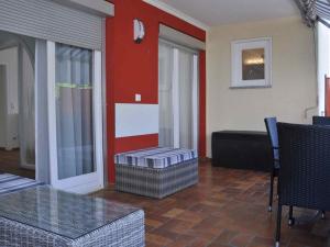 ein Wohnzimmer mit einer roten Wand, einem Tisch und Stühlen in der Unterkunft Ferien-und Gästehaus Wilma in Langenargen