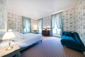 sypialnia z łóżkiem i niebieską kanapą w obiekcie Chambre d'hôtes Château Gigognan w mieście Sorgues