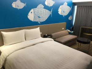 Habitación de hotel con cama y peces en la pared en Chiayi Look Hotel, en Chiayi