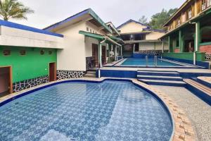 a swimming pool in front of a house at Pesona Wisata Alam Ciparay Endah Mitra RedDoorz in Bogor
