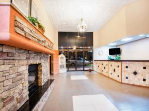 a lobby with a stone fireplace in a building at Travelodge by Wyndham Enid in Enid