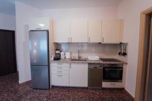 a kitchen with white cabinets and a stainless steel refrigerator at Luxury Apartment in Plaka - Acropolis (Rosemary) in Athens +18 photos