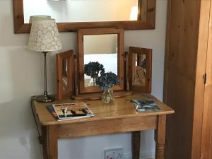 a table with a mirror and a lamp on it at The Coach House Inn in Oakham