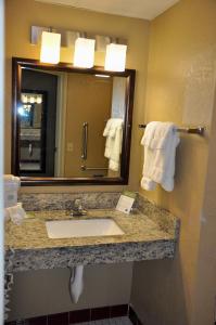 a bathroom with a sink and a mirror and towels at AmericInn by Wyndham Clear Lake in Clear Lake
