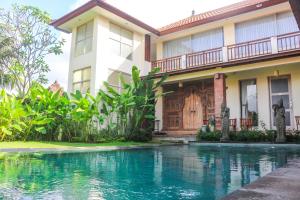 a house with a swimming pool in front of it at Semaya Homestay in Ubud