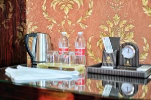 einen Tisch mit einer Cola-Flasche und einer Uhr in der Unterkunft Rosa Del Viento Hotel in Tuapse