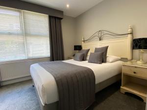 a bedroom with a large white bed and a window at Camelia Hotel in Southend-on-Sea