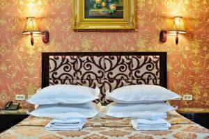 ein Schlafzimmer mit einem Bett mit weißen Kissen darauf in der Unterkunft Rosa Del Viento Hotel in Tuapse