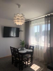 a dining room with a table and chairs and a chandelier at Apartament u Gogoca in Tylicz