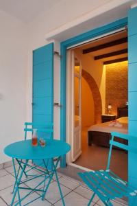 Zimmer mit einem Tisch, Stühlen und einem Bett in der Unterkunft TINOS AQUA PALAZZO in Tinos