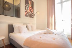 - une chambre avec 2 lits et des draps blancs dans l'établissement Magnifique appartement avec 3 chambres en Hypercentre, à Bordeaux