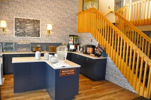 a kitchen with a counter and a staircase in a room at AmericInn by Wyndham Clear Lake in Clear Lake